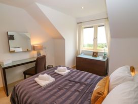 A bedroom with a bed and desk at 25 Ring of Kerry Holiday Cottages, Kenmare
