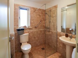 A bathroom with a shower enclosure, toilet, sink and window at 25 Ring of Kerry Holiday Cottages Kenmare