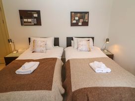 A bedroom with twin beds and bedside tables at 25 Ring of Kerry Holiday Cottages in Kenmare