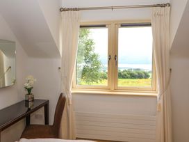 A bedroom with a window and desk at 25 Ring of Kerry Holiday Cottages in Kenmare