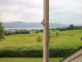 A view through a window showing a landscape with grass and mountains at 25 Ring of Kerry Holiday Cottages, Kenmare