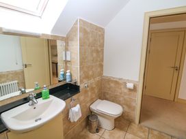 A bathroom with sink, toilet, and mirror at 25 Ring of Kerry Holiday Cottages in Kenmare