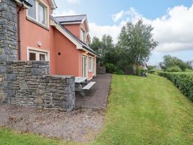 A house with a patio and bench at 25 Ring of Kerry Holiday Cottages in Kenmare