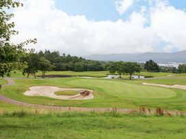 A golf course with sand traps and a pond at 25 Ring of Kerry Holiday Cottages Kenmare
