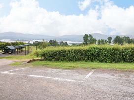 An outdoor view with a car port and lake at 25 Ring of Kerry Holiday Cottages, Kenmare