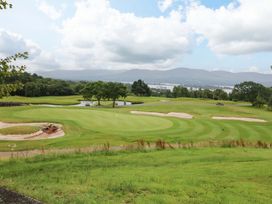 A golf course with sand traps and a water body at 25 Ring of Kerry Holiday Cottages