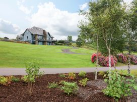 A house with a garden and flower beds at 25 Ring of Kerry Holiday Cottages