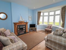 A living room with a fireplace and television at Glen Avon in Seahouses
