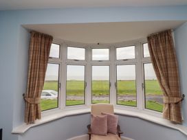 A sitting room with a view of a grassy area outside at Glen Avon in Seahouses