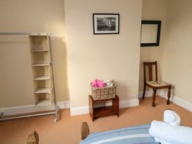 A bedroom with a clothes rack and chair at Glen Avon in Seahouses