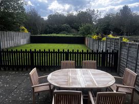 A garden with a wooden table and chairs at Glen Avon in Seahouses