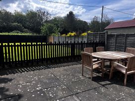 A garden with a wooden table and chairs at Glen Avon in Seahouses