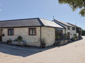 An outdoor view of a stone building with windows and planters at The Sundowner in Wyke Nr. Axminster