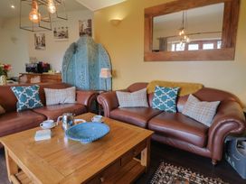 A living room with brown sofas and a coffee table at The Sundowner in Wyke Nr. Axminster