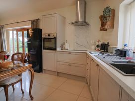 A kitchen with a table and chairs and a refrigerator at The Sundowner in Wyke Nr. Axminster