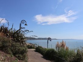 A coastal pathway with plants and a lamppost near the sea at The Sundowner Wyke Nr. Axminster