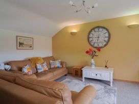 A living room with a sofa and clock at The Granary in Wyke Nr Axminster