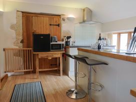 A kitchen with refrigerator, microwave and bar counter at The Granary Wyke Nr Axminster