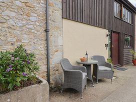 A table and chairs with a wine bottle and glasses at The Granary in Wyke Nr Axminster