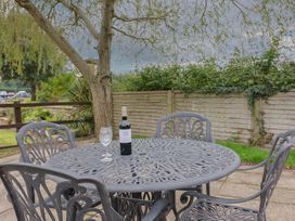 A table with a wine bottle and glass in a garden at The Granary Wyke Nr Axminster