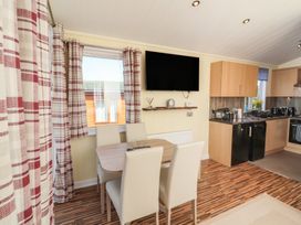 A kitchen with dining table and chairs at Cody Cottage Lodge Mullacott Park near Ilfracombe