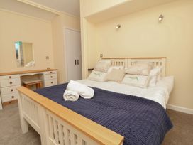 A bedroom with a bed and dresser at Cody Cottage Lodge in Mullacott Park near Ilfracombe