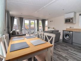 A living room with a dining area and kitchen appliances at Meadows Park 1 in Great Hatfield near Hornsea