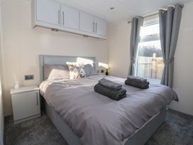 A bedroom with a bed and nightstand at Meadows Park 1 Great Hatfield near Hornsea