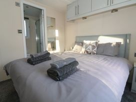 A bedroom with a large bed and towels on top at Meadows Park 1 Great Hatfield near Hornsea