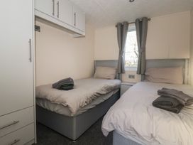 A bedroom with two single beds and storage at Meadows Park 1 Great Hatfield near Hornsea