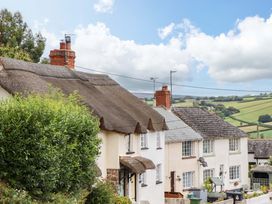 A view of cottages with thatched roofs in the countryside at Cosy Nook South Molton