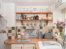 A kitchen with shelves and kitchen appliances at Cosy Nook in South Molton