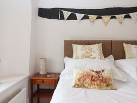 A bedroom with a bed, pillows, and a bedside table at Cosy Nook South Molton