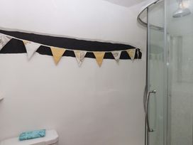 A bathroom with a shower and bunting at Cosy Nook in South Molton