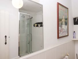 A bathroom with a shower and mirror at Cosy Nook South Molton