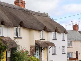 A house with a thatched roof and garden at Cosy Nook in South Molton