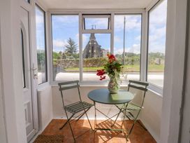A conservatory with a table and chairs at Cae Gwyn in Ty Croes