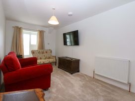 A living room with a sofa and a television at Cae Gwyn in Ty Croes