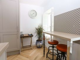 A kitchen with bar stools and a table at Cae Gwyn Ty Croes