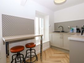 A kitchen with bar stools and a sink at Cae Gwyn in Ty Croes