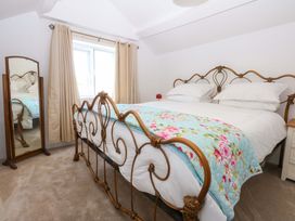 A bedroom with a bed and mirror at Cae Gwyn in Ty Croes