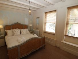 A bedroom with a bed and windows at Greenfingers in Whitby