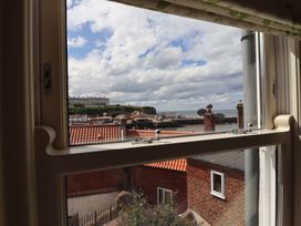 A view from a window showing rooftops and the sea at Greenfingers in Whitby