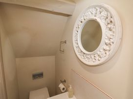 A bathroom with a toilet and a mirror at Greenfingers in Whitby