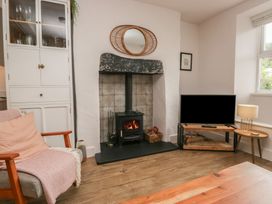 A living room with a fireplace and television at Wansfell Nook in Ambleside