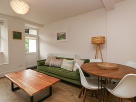 A living room with a green sofa and wooden table at Wansfell Nook in Ambleside
