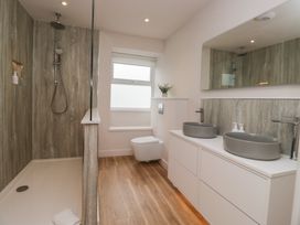 A bathroom with a shower, toilet, and sinks at Wansfell Nook in Ambleside