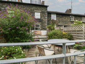 A garden with a stone wall and outdoor seating at Wansfell Nook Ambleside