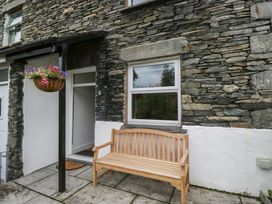 A wooden bench and flowers in a hanging basket at Wansfell Nook in Ambleside