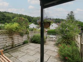 A garden with a stone patio and table and chairs at Wansfell Nook in Ambleside